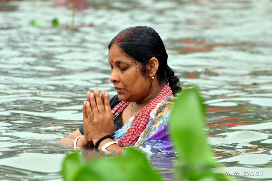 A woman offers prayers in the Brahmputra river during Astami Snan religious festival at Langalbandh, southeast of Dhaka, Bangladesh, on April 18, 2013. Thousands of Hindu devotees Thursday celebrated one of the largest religious festivals of the Hindu community Astami Snan across the country. (Xinhua/Shariful Islam) 