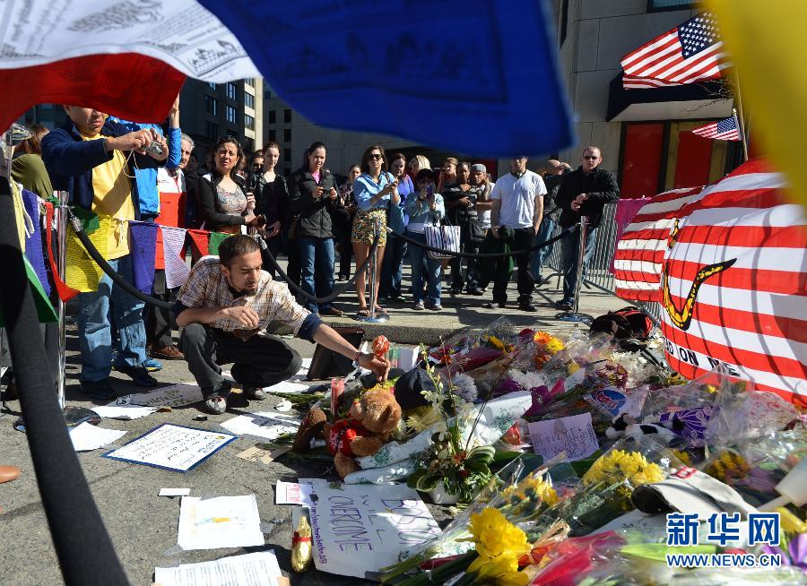 A citizen offers flowers for the victims in Boston Marathon blasts in Boston, the United States, April 17, 2013. (Xinhua/Wang Lei)