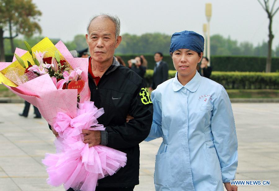 An H7N9 patient surnamed Yang (L) is discharged from Shanghai Public Health Clinic Center after being successfully treated in Shanghai, east China, April 18, 2013. The 66-year-old Shanghai man showed flu symptoms on March 31 and was confirmed to be infected on April 6. Doctors said he now carries antibodies against the virus and will not be infected again. (Xinhua/Ding Ting) 