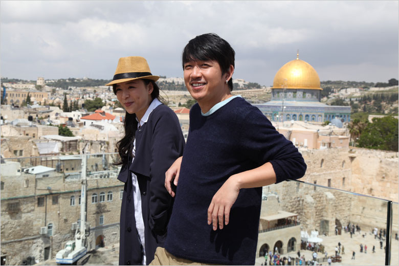 Actress Zhang Jingchu (L) and actor Pan Yueming pose for photos during a break from filming the movie "The Old Cinderella" on the roof of Aish Hatorah near the Western Wall in the Old City of Jerusalem on Thursday, April 18, 2013. [Photo: CRIENGLISH.com / Zhang Jin]  