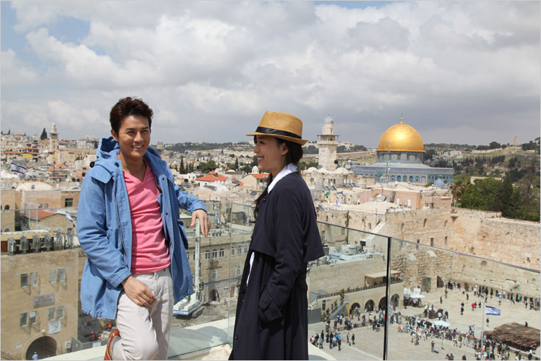 Actress Zhang Jingchu (R) and actor Kenji Wu pose for photos during a break from filming the movie "The Old Cinderella" on the roof of Aish Hatorah near the Western Wall in the Old City of Jerusalem on Thursday, April 18, 2013. [Photo: CRIENGLISH.com / Zhang Jin] 