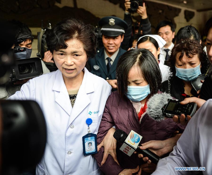 An H7N9 avian influenza patient (R) surnamed Jia is escorted to leave the hospital in Hangzhou, capital of east China's Zhejiang Province, April 19, 2013. Fifty-one-year-old Jia, as confirmed the first H7N9 positive case in Zhejiang, was discharged from hospital on Friday after her symptom returned normal. (Xinhua/Xu Yu)