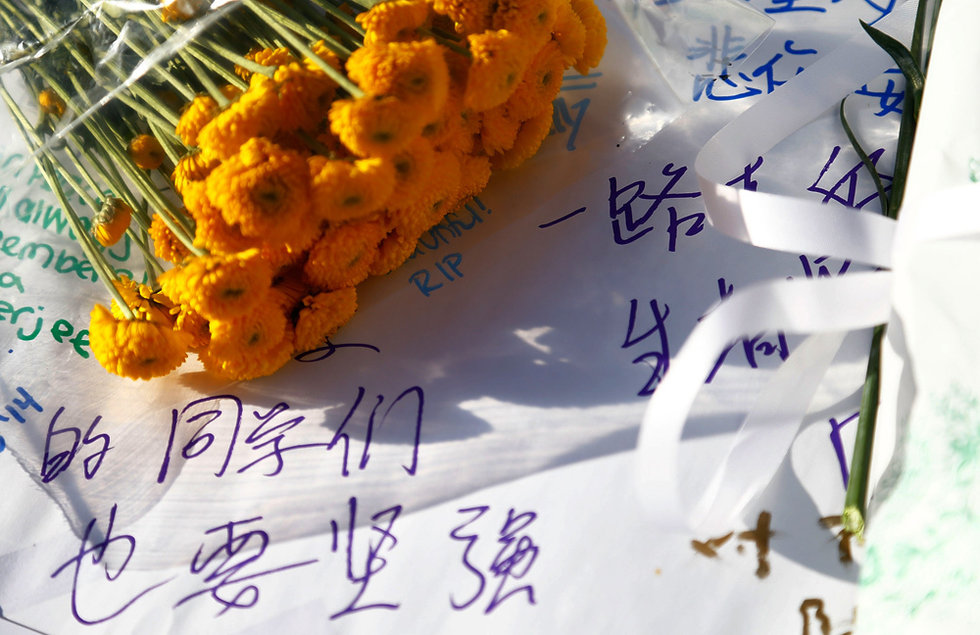 Students write down blessing words for Lu Lingzi, the Chinese victim in Boston marathon blast, in Boston University on April 17.