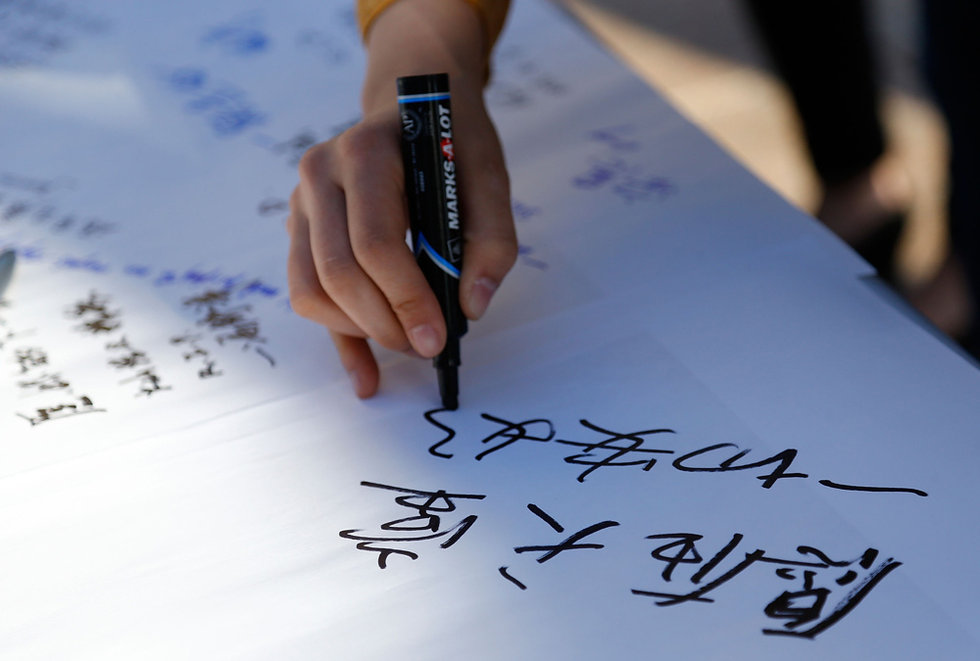 Students write down blessing words for Lu Lingzi, the Chinese victim in Boston marathon blast, in Boston University on April 17.