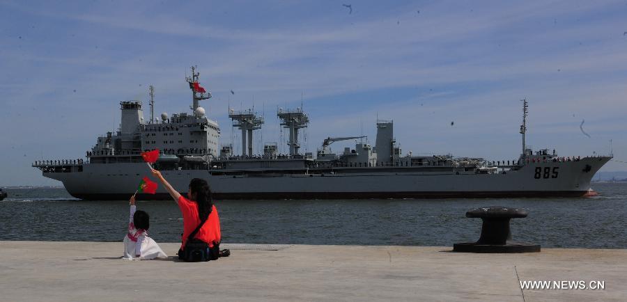 A Chinese woman with her kid sees Chinese navy escort fleet off in Lisbon, capital of Portugal, April 19, 2013. The Chinese navy escort fleet left Lisbon Friday for France after winding up a five-day goodwill visit to Portugal. (Xinhua/Zhang Liyun)