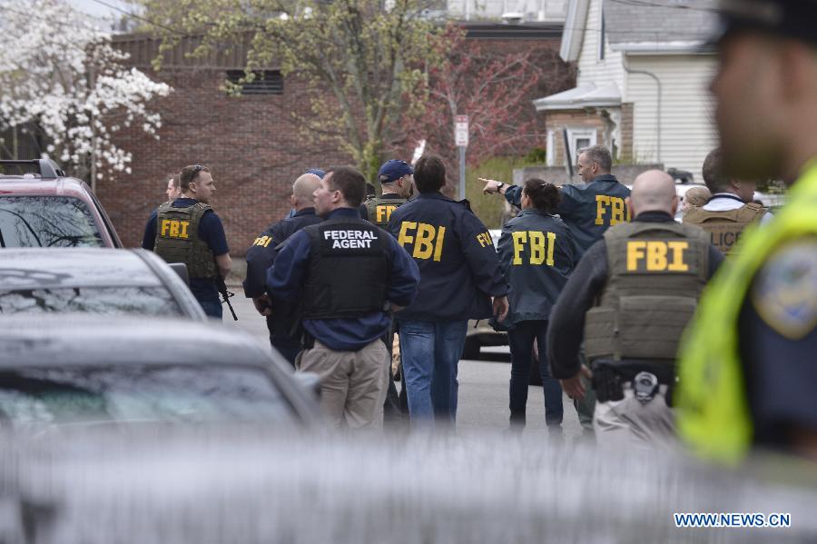 Members of FBI search for suspect in Camebridge neighbourhood of Boston, Massachusetts, April 19, 2013. Two men sought in the Boston Marathon bombing killed a police officer, wounded another in a firefight and hurled explosive devices at police during their getaway attempt in a night of violence that left one suspect dead and the other on the loose early Friday. (Xinhua/Zhang Jun) 