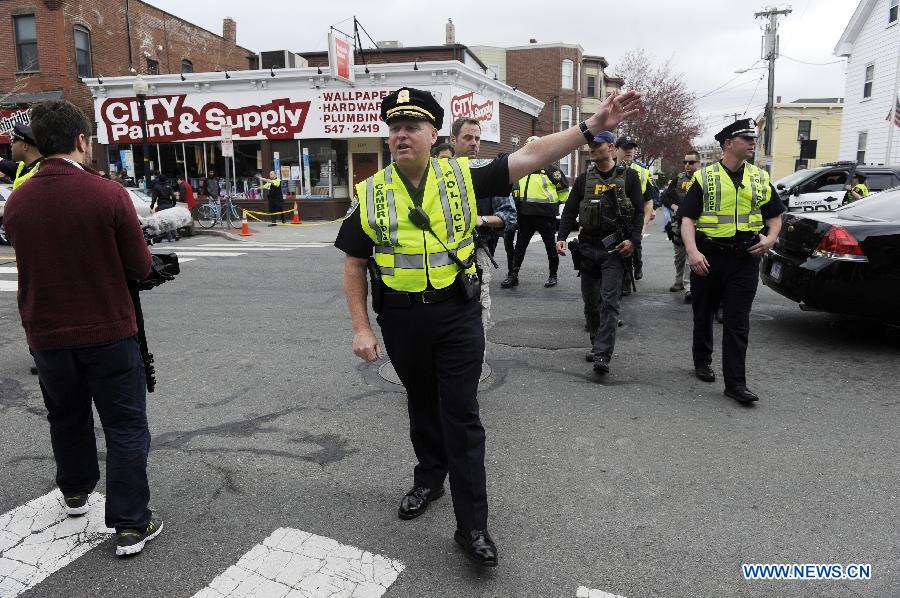 Policemen searching for suspects demand reporters to evacuate in Camebridge neighbourhood of Boston, Massachusetts, April 19, 2013. Two men sought in the Boston Marathon bombing killed a police officer, wounded another in a firefight and hurled explosive devices at police during their getaway attempt in a night of violence that left one suspect dead and the other on the loose early Friday. (Xinhua/Zhang Jun) 