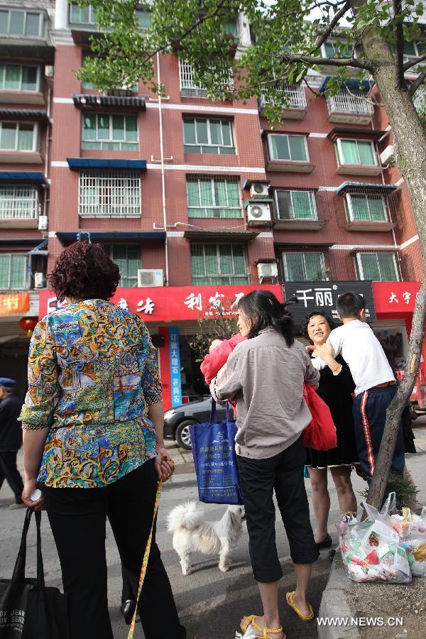 People gather outside their apartments to avoid aftershocks of a quake, in Shifang City of southwest China's Sichuan Province, April 20, 2013. A 7.0-magnitude earthquake hit Lushan County of Sichuan Province at 8:02 a.m. Beijing Time (0002 GMT) on Saturday, according to the China Earthquake Networks Center (CENC). The epicenter, with a depth of 13 kilometers, was monitored at 30.3 degrees north latitude and 103.0 degrees east longitude. (Xinhua/Zhang Xiaoli)