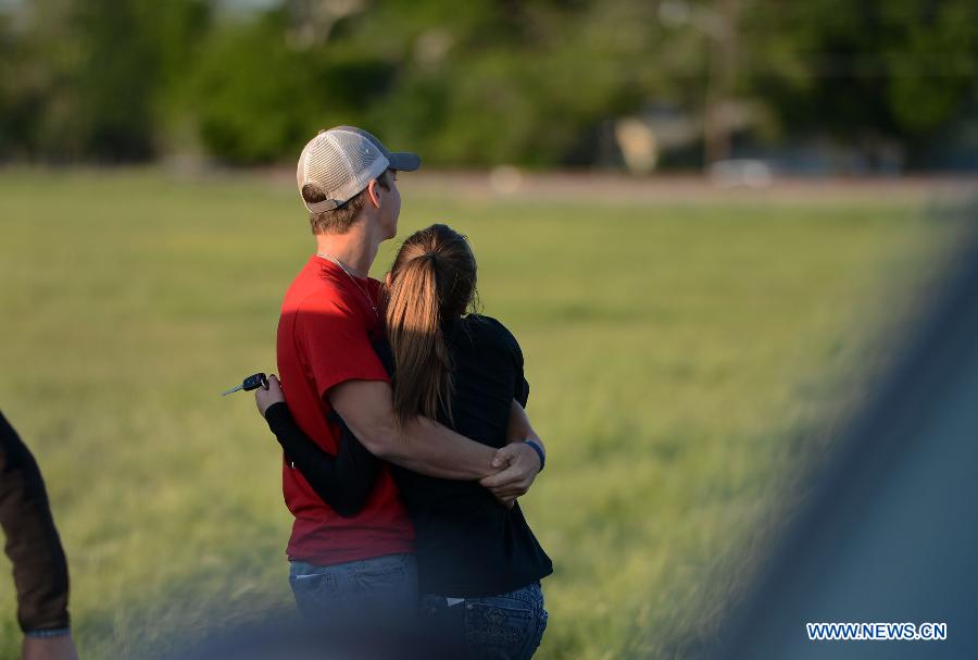 A couple hug each other at a community center in West, Texas, the United States, April 19, 2013. The massive explosion at a Texas fertilizer plant on Wednesday has killed 14 people and injured more than 160 others, local authorities said Thursday. Texas Governor Rick Perry has declared McLennan County a disaster area, saying he would ask for federal disaster aid from President Barack Obama. (Xinhua/Wang Lei) 