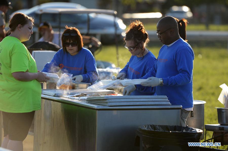 A woman receives food aid at a community center in West, Texas, the United States, April 19, 2013. The massive explosion at a Texas fertilizer plant on Wednesday has killed 14 people and injured more than 160 others, local authorities said Thursday. Texas Governor Rick Perry has declared McLennan County a disaster area, saying he would ask for federal disaster aid from President Barack Obama. (Xinhua/Wang Lei)