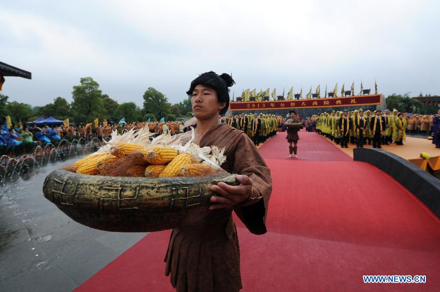 A worshipper presents offerings during a memorial ceremony in honor of Da Yu, a legendary Chinese hero who tamed the Yellow River and made it beneficial to farming in the prehistorical era, held in Shaoxing City, east China's Zhejiang Province, April 20, 2013. (Xinhua/Ju Huanzong)