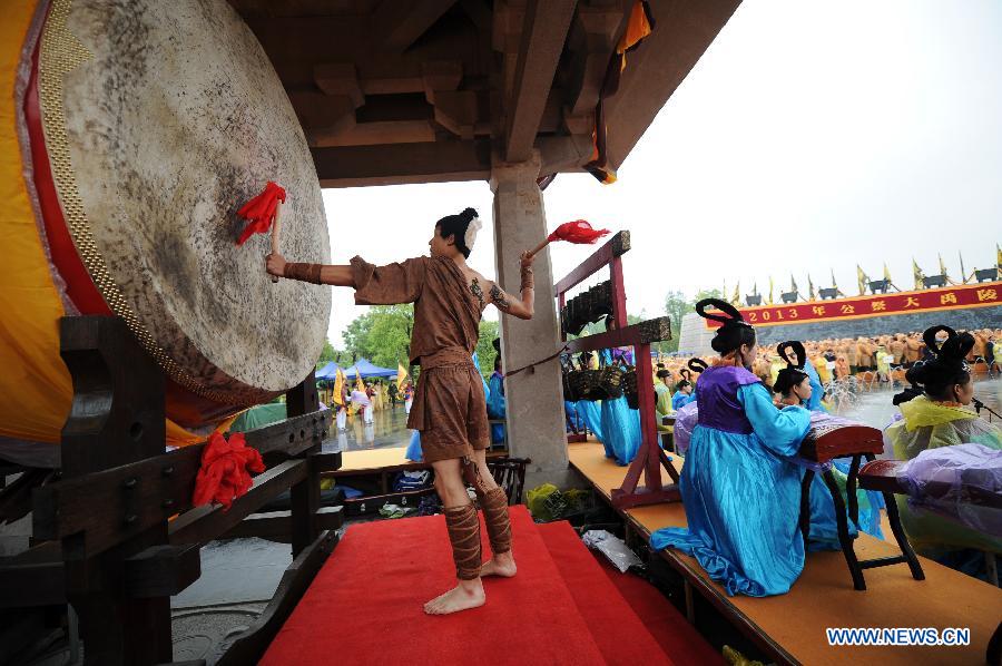 A worshipper hits a drum during a memorial ceremony in honor of Da Yu, a legendary Chinese hero who tamed the Yellow River and made it beneficial to farming in the prehistorical era, held in Shaoxing City, east China's Zhejiang Province, April 20, 2013. (Xinhua/Ju Huanzong)