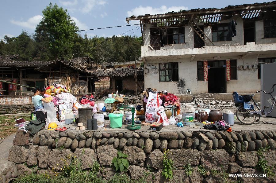 Residents salvage articles for daily live usage outside of their damaged house after a 7.0-magnitude earthquake in Longmen Township, Lushan County, Ya'an City of southwest China's Sichuan Province, April 20, 2013. At least 102 people were killed in the earthquake in Sichuan, according to the China Earthquake Administration on Saturday afternoon. (Xinhua/Zhang Xiaoli) 