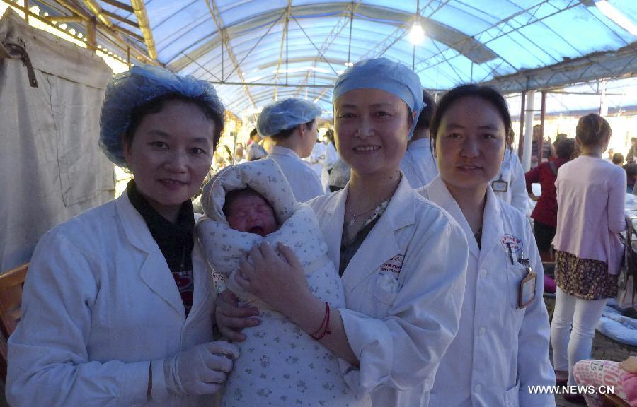 Health workers pose for a photo with a newly-born baby in the quake-hit Ya'an City, southwest China's Sichuan Province, April 20, 2013. The baby was born in an ambulance in Ya'an, almost two hours after a 7.0-magnitude earthquake hit Lushan county of Ya'an City on Saturday. (Xinhua/Wang Dan) 