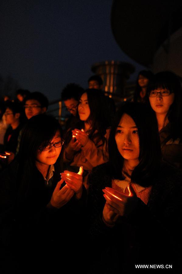 Students hold candles while attending a vigil to express their well-wishes to people in quake-hit Ya'an in southwest China's Sichuan Province at Jilin University in Changchun, capital of northeast China's Jilin Province, April 20, 2013. A total of 156 people have been killed in the 7.0-magnitude earthquake in southwest China's Sichuan Province as of 8:50 p.m. Saturday, according to the China Earthquake Administration. (Xinhua/Xu Chang)