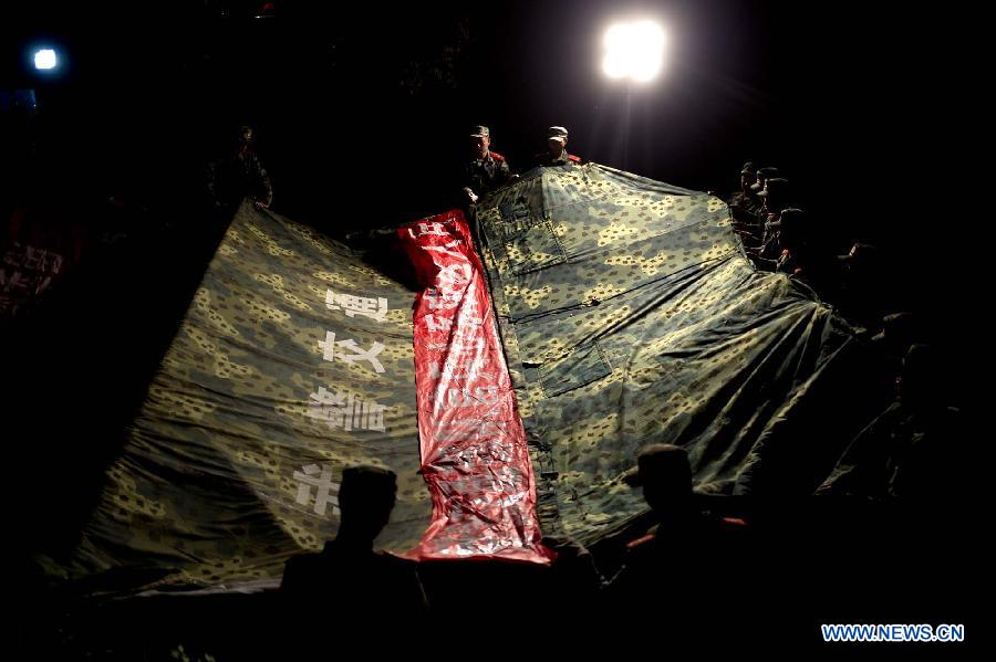 Soldiers build camps overnight to prepare for tomorrow's rescue work at Yuxi Village in severely-hit Baosheng Township of the quake-hit Lushan County, Ya'an City, southwest China's Sichuan Province, April 20, 2013. A total of 160 people had been killed in the 7.0-magnitude earthquake in southwest China's Sichuan Province as of 0:00 a.m Sunday, according to the country's seismological bureau. (Xinhua/Fei Maohua)