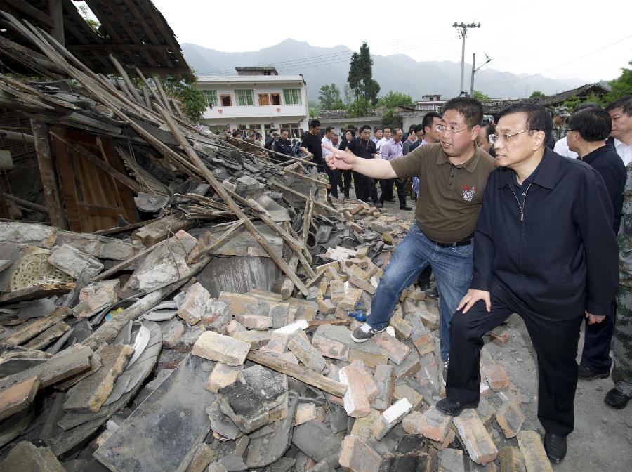 Chinese Premier Li Keqiang (R), also a member of the Standing Committee of the Political Bureau of the Communist Party of China Central Committee, inspects the damages at severely-hit Shuangshi Township in the quake-hit Lushan County, southwest China's Sichuan Province, April 20, 2013. Li Keqiang arrived in Sichuan Saturday afternoon to deploy quake relief work. (Xinhua/Huang Jingwen)