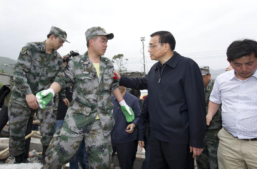 Chinese Premier Li Keqiang (2nd R) learns rescue work from a soldier as he inspects the severely-hit Shuangshi Town in the quake-hit Lushan County, southwest China's Sichuan Province, April 20, 2013. Li Keqiang arrived in Lushan County Saturday afternoon to deploy quake relief work. (Xinhua/Huang Jingwen)