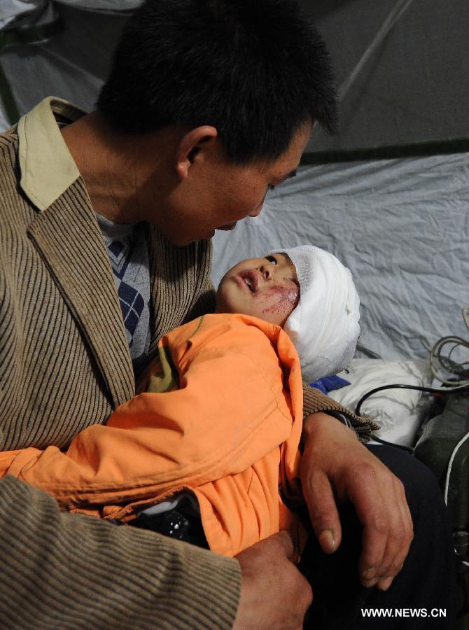 The injured 3-year-old girl Zheng Bin rests in her father's arms in a temporary tent outside the Lushan People's Hospital in Lushan County of Ya'an City, southwest China's Sichuan Province, April 21, 2013. A 7.0-magnitude earthquake which hit Lushan County on April 20 morning damaged the Lushan People's Hospital and doctors had to erect temporary tents outside the hosptial to treat the injured people. (Xinhua/Li Jian) 