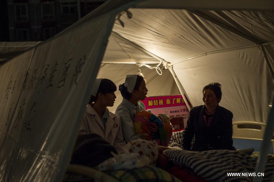 Doctors and nurses pacify victims in a temporary tent outside the Lushan People's Hospital in Lushan County of Ya'an City, southwest China's Sichuan Province, April 21, 2013. A 7.0-magnitude earthquake which hit Lushan County on April 20 morning damaged the Lushan People's Hospital and doctors had to erect temporary tents outside the hosptial to treat the injured people. (Xinhua/Chen Cheng) 