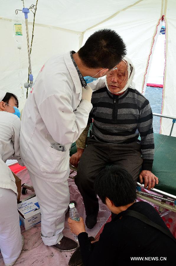 Medical staff of the Red Cross Society of China treat an injured in a temporary tent in Lushan County of Ya'an City, southwest China's Sichuan Province, April 20, 2013. A 7.0-magnitude earthquake jolted Lushan County on April 20 morning and by now more than 330 medical workers and voluteers from the Red Cross Society conduct relief work in the quake-hit region. (Xinhua/Deng Yinhui)  