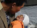 The injured 3-year-old girl Zheng Bin rests in her father's arms