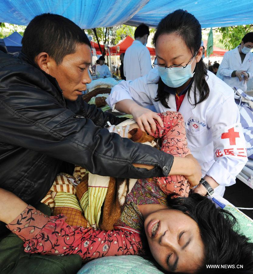 Doctors from Beijing, capital of China, give treatment to an injured person at the Second People's Hospital in Ya'an City, southwest China's Sichuan Province, April 21, 2013. A 7.0-magnitude earthquake hit Lushan County of Ya'an City in Sichuan Province on Saturday morning, leaving 180 people dead and 11,227 others injured so far. (Xinhua/Chen Shugen)