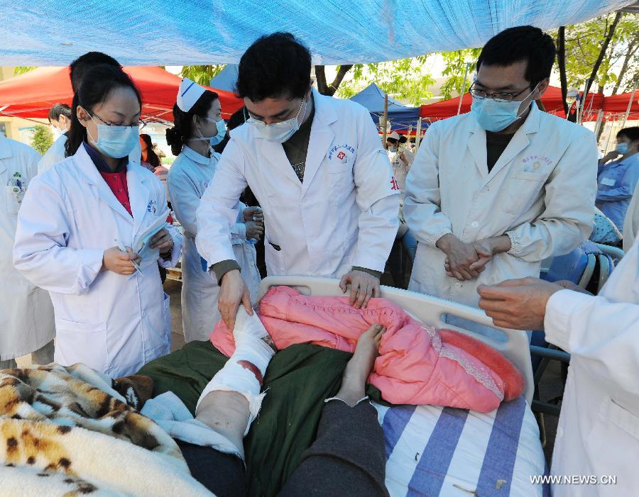 Doctors from Beijing, capital of China, give treatment to an injured person at the Second People's Hospital in Ya'an City, southwest China's Sichuan Province, April 21, 2013. A 7.0-magnitude earthquake hit Lushan County of Ya'an City in Sichuan Province on Saturday morning, leaving 180 people dead and 11,227 others injured so far. (Xinhua/Chen Shugen)