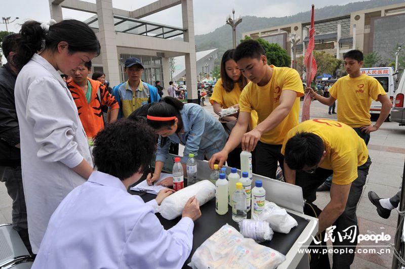 Volunteers send medicines and waters to the People's Hospital in Lushan, Sichuan province, April 21, 2013. More than 3,000 people had been sent here to get treatment as of 11:30 a.m. of April 21, 2013. (Weng Qiyu/People’s Daily Online)