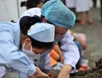 A nurse treats a wounded woman in hospital