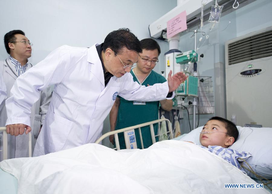 Chinese Premier Li Keqiang visits a patient seriously injured in an earthquake, at Huaxi Hospital in Chengdu, capital of southwest China's Sichuan Province, April 21, 2013. A 7.0-magnitude earthquake jolted Lushan County of Sichuan Province on April 20 morning. (Xinhua/Huang Jingwen) 