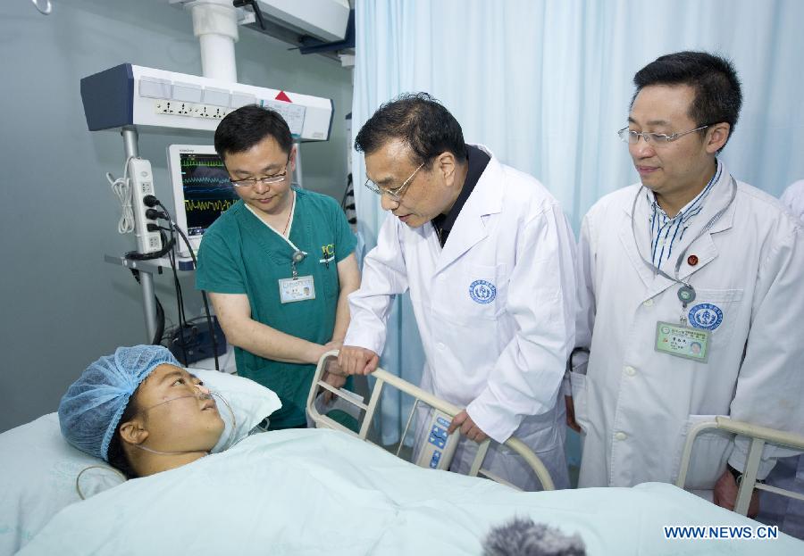 Chinese Premier Li Keqiang (2nd R) visits a patient seriously injured in an earthquake, at Huaxi Hospital in Chengdu, capital of southwest China's Sichuan Province, April 21, 2013. A 7.0-magnitude earthquake jolted Lushan County of Sichuan Province on April 20 morning. (Xinhua/Huang Jingwen) 