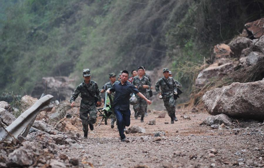 Soldiers run through a landslide area between severely-hit Longmen Town and Baosheng Town of Lushan County in Ya'an City, southwest China's Sichuan Province, April 21, 2013. The road linking Longmen and Baosheng was reopened on Sunday, making the life passage for Taiping Town and Baosheng Town open. A 7.0-magnitude earthquake jolted Lushan County on April 20.(Xinhua/Jiang Hongjing) 