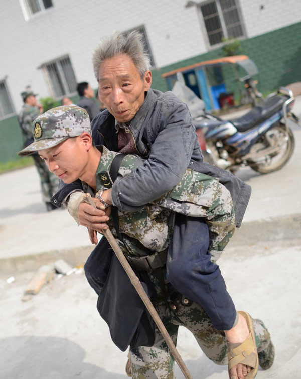 A soldier carries an old man to safety in Lushan county, Ya'an city in Southwest China's Sichuan province, on April 20, 2013. (Photo/Xinhua)