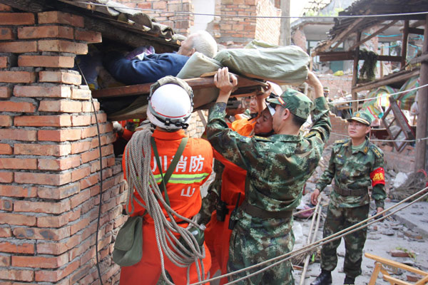Rescue soldiers carry an old man out of a collapsed house in Renjia village of quake-hit Lushan county, Southwest China's Sichuan province, on April 20, 2013. (Photo/Xinhua)