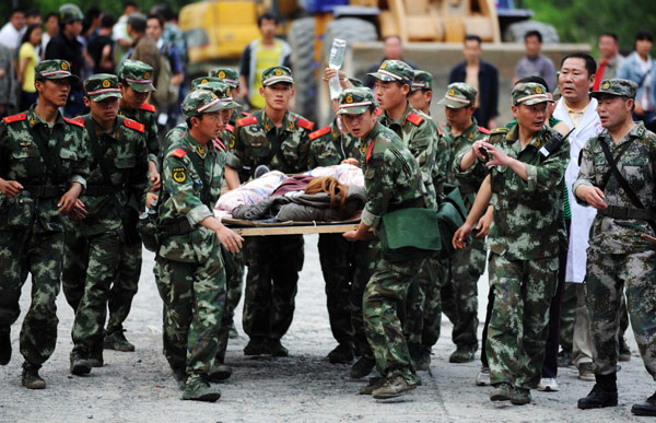 Rescue soldiers carry an injured person to safety in Lushan county, Southwest China's Sichuan province, on April 20, 2013. (Photo/Xinhua)