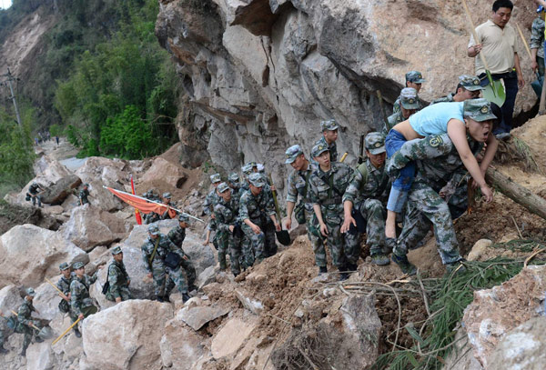 Rescue soldiers carry injured people to safety in Baosheng township, Lushan county in Southwest China's Sichuan province, on April 20, 2013. (Photo/Xinhua)