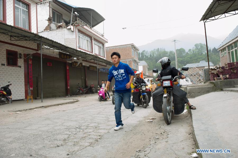 People move towards open field when an aftershock occurs in quake-hit Lushan County in Ya'an City, southwest China's Sichuan Province, April 21, 2013. A 7.0-magnitude earthquake jolted Lushan County on April 20 morning. Aftershocks continued to rock the region. (Xinhua/Chen Cheng)