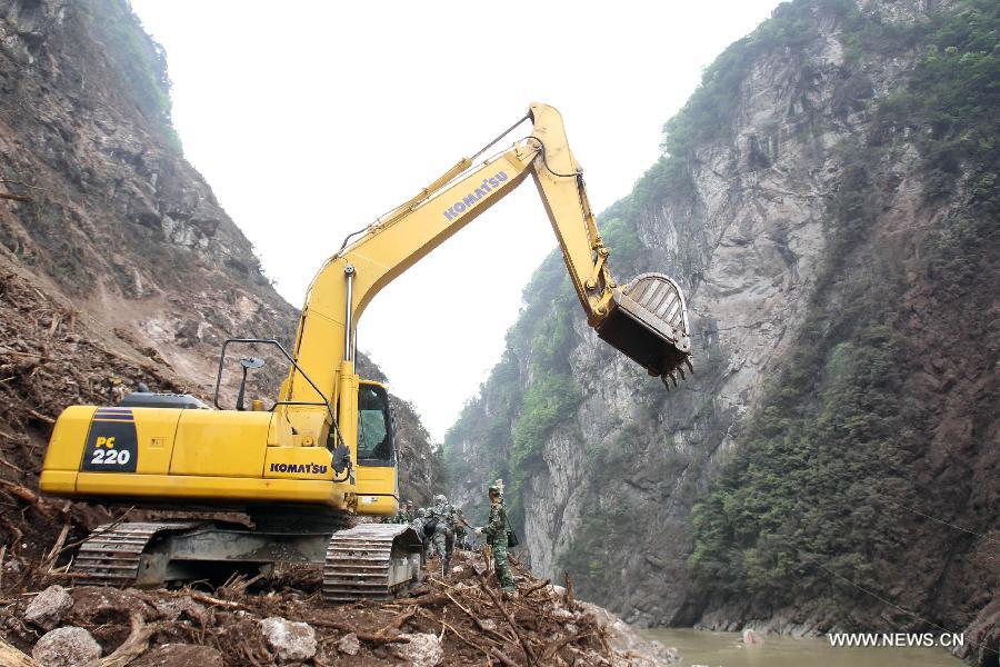 Armed police hydropower troops operate a bulldozer to repair a road leading to Baosheng Township, a worst quake-hit area, in Lushan County, southwest China's Sichuan Province, April 21, 2013. A 7.0-magnitude quake jolted Lushan County of Sichuan's Ya'an City at 8:02 a.m. Saturday Beijing Time, according to the China Earthquake Networks Center. Military and civilian rescue teams are struggling to reach every household in Lushan and neighboring counties. (Xinhua/Bai Xuefei) 