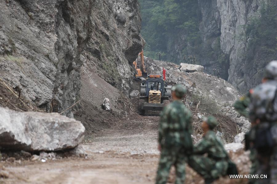 Armed police hydropower troops operate a bulldozer to repair a road leading to Baosheng Township, a worst quake-hit area, in Lushan County, southwest China's Sichuan Province, April 21, 2013. A 7.0-magnitude quake jolted Lushan County of Sichuan's Ya'an City at 8:02 a.m. Saturday Beijing Time, according to the China Earthquake Networks Center. Military and civilian rescue teams are struggling to reach every household in Lushan and neighboring counties. (Xinhua/Bai Xuefei)