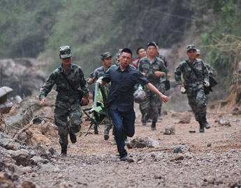 Soldiers run through a landslide area in Lushan County 