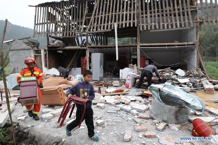 A rescuer helps local residents to salvage properties from their damaged house in Baosheng Township, Lushan County, southwest China's Sichuan Province, April 21, 2013. Death toll has risen to 208 in the earthquake in Sichuan as of 5:00 p.m. Sunday, according to latest statistics gathered by local authorities. A 7.0-magnitude earthquake hit Lushan County at 8:02 a.m. Saturday Beijing time. (Xinhua/Zhang Xiaoli) 