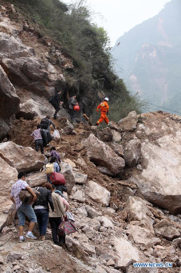 People walk on rocks fallen due to the landslide triggered by a strong quake in Baosheng Township, Lushan County, southwest China's Sichuan Province, April 21, 2013. Death toll has risen to 208 in the earthquake in Sichuan as of 5:00 p.m. Sunday, according to latest statistics gathered by local authorities. A 7.0-magnitude earthquake hit Lushan County at 8:02 a.m. Saturday Beijing time. (Xinhua/Zhang Xiaoli) 