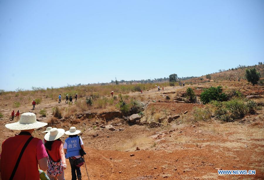 Volunteers and staff members of One Foundation, an NGO founded by actor Jet Li, walk past a dried-up cistern in Yunfeng Village of Wumao Township in Yuanmou County of Yi Autonomous Prefecture of Chuxiong, southwest China's Yunnan Province, April 20, 2013. One Foundation and China Merchants Bank co-sponsored a public benefit activity here to help drought-hit local residents getting drinking water. Volunteers also joined to communicate with local residents to learn about the drought in Chuxiong, which started since 2009. (Xinhua/Qin Lang) 