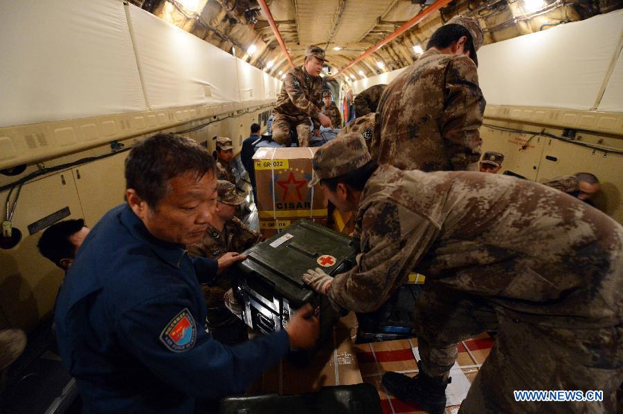 Members of China International Search and Rescue Team (CISAR) carry relief materials to an aircraft which is about to fly to the earth-quake region at Nanyuan Airport in Beijing, capital of China, April 20, 2013. A total of 140 rescuers and 12 sniffer dogs flied to the earthquake-hit Lushan County, southwest China's Sichuan Province, Saturday night to conduct rescue work. (Xinhua/Yu Hongchun)