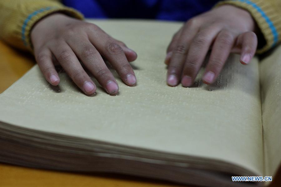 A visually impaired child reads a braille book during a reading party in the China Braille Library in Beijing, capital of China, April 21, 2013. A reading party for the visually impaired children was held here on Sunday. Li Yanyan, a visually-challenged physician who achieved a medical doctor degree at Palmer West College of Chiropractic in California, the U.S., participated in the reading party with his autobiography and shared his learning experience with the young readers and their parents. (Xinhua/Xu Zijian) 