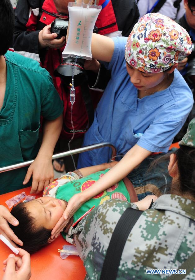 A nurse takes care of an injured boy in the People's Hospital in the quake-hit Lushan County, southwest China's Sichuan Province, April 21, 2013. Military and civilian rescue teams are struggling to reach every household in Lushan and neighboring counties of southwest China's Sichuan Province, badly hit by Saturday's strong earthquake. (Xinhua/Li Hualiang) 