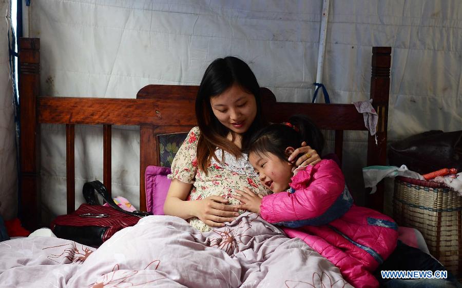 Han Wenyang, a pregnant woman, rests in a tent with her niece in Taiping Town, Lushan County, southwest China's Sichuan Province, April 21, 2013. Military and civilian rescue teams are struggling to reach every household in Lushan and neighboring counties of southwest China's Sichuan Province, badly hit by Saturday's strong earthquake. (Xinhua/Jiang Hongjing) 