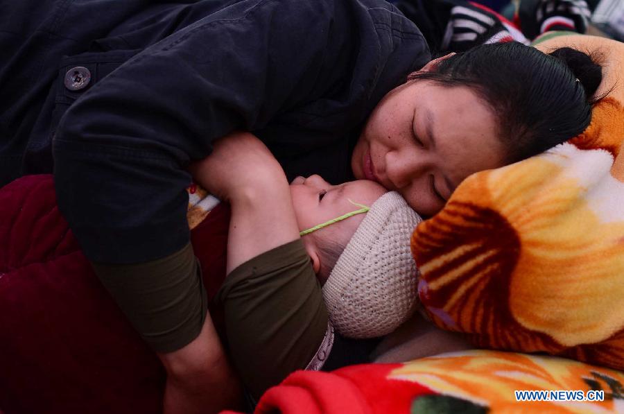 A mother holds her kid and falls asleep in a shelter in Lushan County, southwest China's Sichuan Province, April 21, 2013. Military and civilian rescue teams are struggling to reach every household in Lushan and neighboring counties of southwest China's Sichuan Province, badly hit by Saturday's strong earthquake. (Xinhua/Jiang Hongjing) 