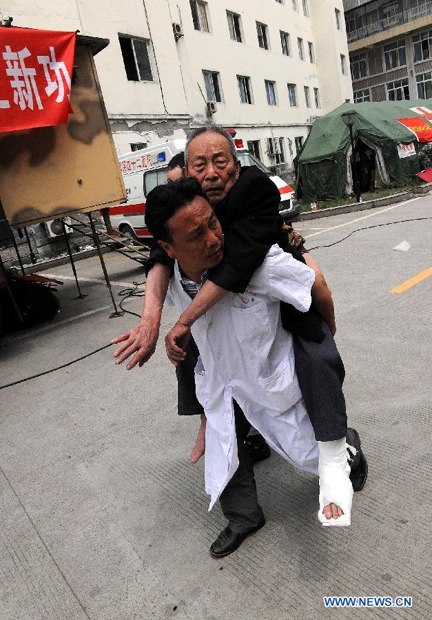 A surgeon carries an injured man on his back to the place for x-ray in the People's Hospital in the quake-hit Lushan County, southwest China's Sichuan Province, April 21, 2013. Military and civilian rescue teams are struggling to reach every household in Lushan and neighboring counties of southwest China's Sichuan Province, badly hit by Saturday's strong earthquake. (Xinhua/He Junchang) 